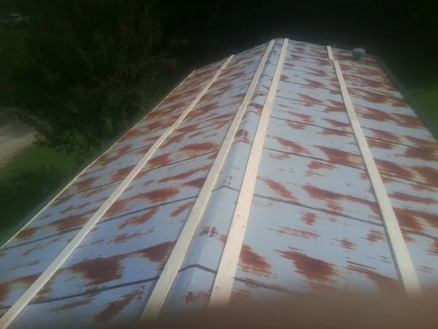 Rusted metal roof panels with new wood purlins before replacement — Storm Damage Roof Repair in Krum by Roofing Brothers