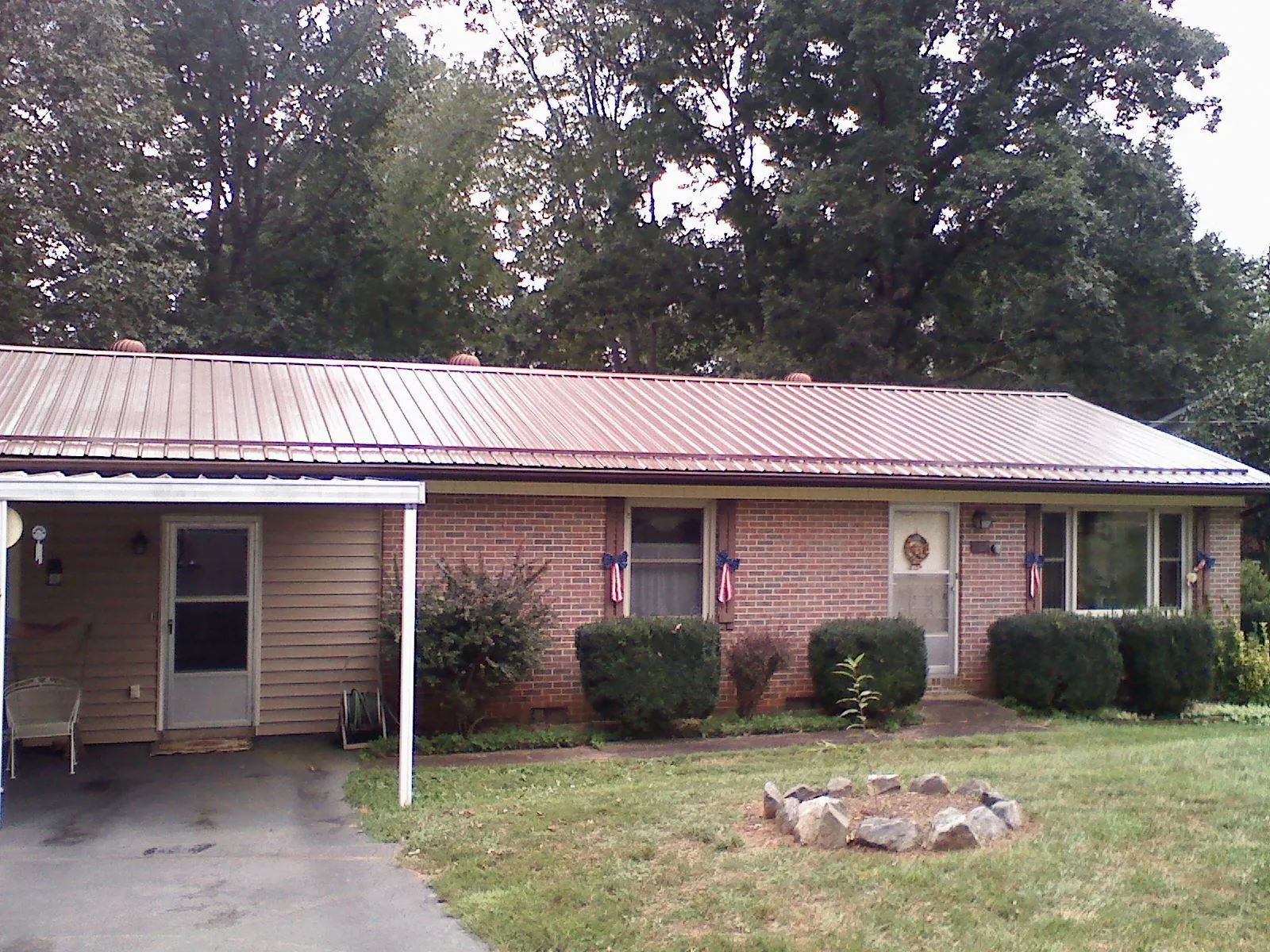 Bronze metal roof and carport on a brick ranch home — Roof Repair work by our crew in Krum